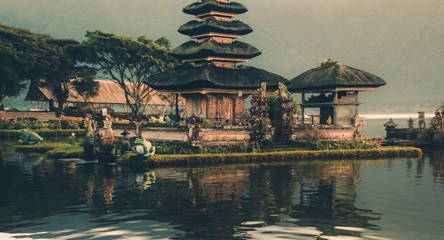 temple beside body of water and trees