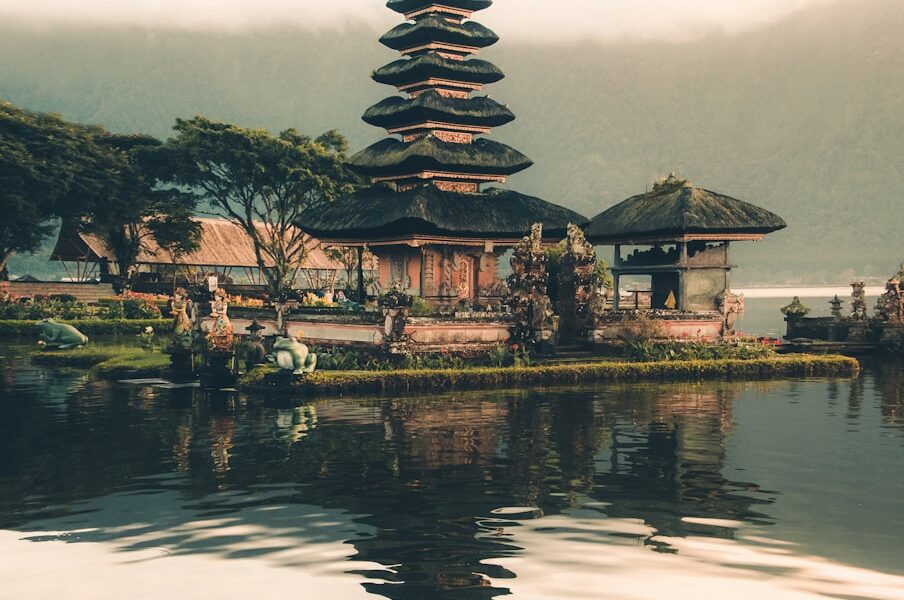 temple beside body of water and trees